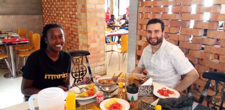 Two travellers sharing a meal at a restaurant in Uganda